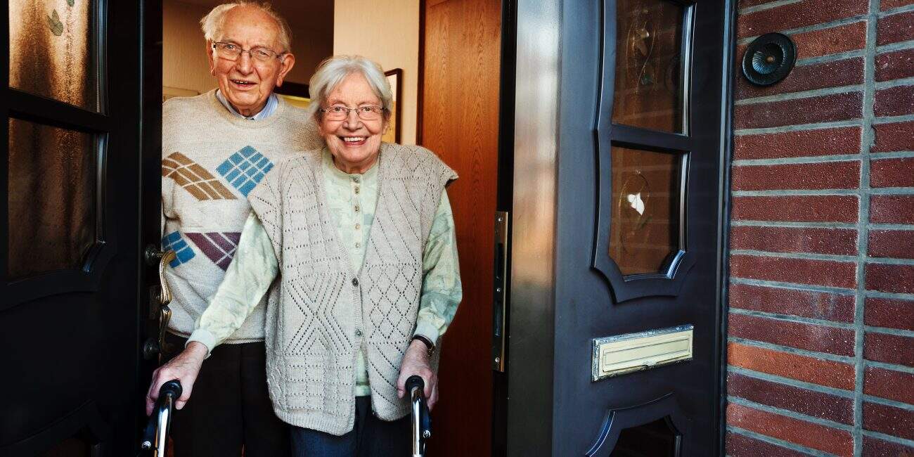 elderly couple opening the front door